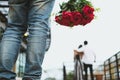 Heartbroken man holding bouquet of red roses feeling sad while s Royalty Free Stock Photo