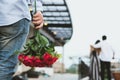 Heartbroken man holding bouquet of red roses feeling sad while s Royalty Free Stock Photo