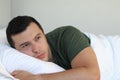 Heartbroken young man laying down in bed Royalty Free Stock Photo