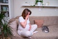 Heartburn and nausea in a pregnant woman on the couch, stomach problems during pregnancy