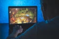 Hearthstone is a free-to-play online digital collectible card game. Video computer game. Man play video game on laptop Royalty Free Stock Photo