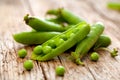 Hearthy fresh green peas and pods on rustic wooden background.