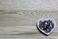 Hearts beads of metal on wooden background.