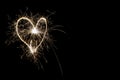 Hearts on a dark background drawn by a sparkler.