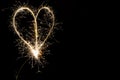 Hearts on a dark background drawn by a sparkler.