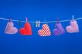 hearts hanging on a clothesline with clothespins, blue background