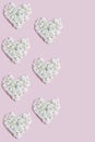 hearts lined with white hydrangea flowers. layout for Valentine`s day on a pink background.
