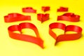 Hearts made from red, satin ribbon on yellow background. Valentines Day concept. Royalty Free Stock Photo