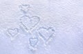 Hearts written on the fresh white blue snow surface in winter