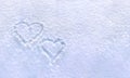 Hearts written on the fresh white blue snow surface in winter