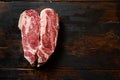 Heartshape Raw Chuck beef steak on vintage dark wood table Organic beef. Black Top view. Space for text