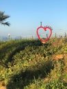 Heartshaped sculpture amidst grassy field under the open sky Royalty Free Stock Photo