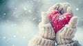 snow falling hands in white knitted gloves holding a red snow heart