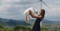 This heartwarming video captures a joyful scene of a happy little girl standing in a field, with wind turbines wind