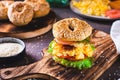 Hearty bagel burger with scramble egg, bacon, cheese, tomato and lettuce Royalty Free Stock Photo