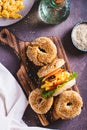 Hearty bagel burger with scramble egg, bacon, cheese, tomato and lettuce top and vertical view Royalty Free Stock Photo
