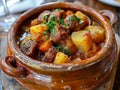 A hearty beef stew cooked with tender chunks of beef, potatoes, carrots, and herbs,served in a rustic clay pot. Royalty Free Stock Photo