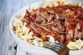 Hearty bowl of beef ragu over egg noodles