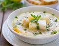 hearty bowl of Cullen Skink, a traditional Scottish soup, served with grilled bread on a rustic wooden table, suggesting a