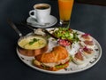 Hearty breakfast - corn porridge, croissant with sliced chicken, rucola, tomato and cheese salad with pesto sauce, boiled chicken Royalty Free Stock Photo