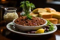 Hearty chili bowl with cornbread and sour cream in ultra wide angle view at dusk