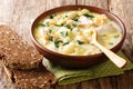 Hearty cream soup with gnocchi, chicken and spinach served with bread close-up in a bowl. horizontal Royalty Free Stock Photo