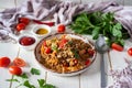 A hearty family lunch: buckwheat with vegetables stewed with spices and fresh herbs in a beautiful plate. Close-up