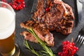 Hearty food. Hot steak with rosemary, red berries, juicy cuts of meat grilled on a slate stone board