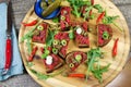 Hearty hefty german snack: isolated wood plate with roasted beef tatar garlic bread, spring onions, capers, pickled cucumbers Royalty Free Stock Photo