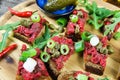 Hearty hefty german snack: isolated wood plate with roasted beef tatar garlic bread, spring onions, capers, pickled cucumbers Royalty Free Stock Photo