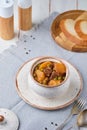 Hearty Irish stew of beef, potatoes and green peas in beer sauce in a ceramic pot on a light wooden background. Irish cuisine Royalty Free Stock Photo