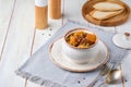 Hearty Irish stew of beef, potatoes and green peas in beer sauce in a ceramic pot on a light wooden background. Irish cuisine Royalty Free Stock Photo