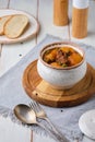 Hearty Irish stew of beef, potatoes and green peas in beer sauce in a ceramic pot on a light wooden background. Irish cuisine Royalty Free Stock Photo