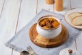 Hearty Irish stew of beef, potatoes and green peas in beer sauce in a ceramic pot on a light wooden background. Irish cuisine Royalty Free Stock Photo