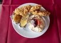 Hearty lunch featuring chicken friend with corn flakes, cole slaw, and baked potatoe in a Hungarian restaurant.