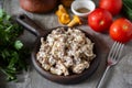 Hearty lunch: fried chanterelles with sour cream and fresh herbs in a beautiful plate on a gray background. Fried Royalty Free Stock Photo