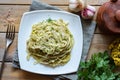 Hearty lunch: vegetarian pasta with cheese, vegetables and herbs on a white plate. Top view