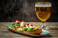 Hearty snack with different kinds of spreads on farmhouse bread served with a fresh yeast wheat beer on an old wooden table