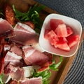 hearty snack in a restaurant with ham, salami, rocket and cheese and a bowl of melon