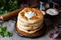 A hearty snack: a stack of fluffy tortillas with cheese and sour cream on a wooden plate. Tortillas with cheese for