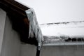 The heat from the house passes through the roof and melts the snow. it freezes in the eaves of the roof and forms icicles. repel t Royalty Free Stock Photo