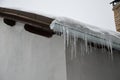 The heat from the house passes through the roof and melts the snow. it freezes in the eaves of the roof and forms icicles. repel t