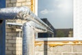 Heat insulated pipeline. Thermal insulation of hot water pipes with foil and cotton wool. Industrial air conditioner Royalty Free Stock Photo