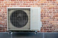 Heat pump air conditioning outdoor unit hanging on wall. Royalty Free Stock Photo