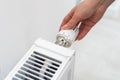 Heat radiator knob. Woman hand adjusting temperature on heating radiator Royalty Free Stock Photo