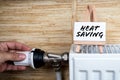 Heat Saving. Turning down thermostat on radiator to save energy Royalty Free Stock Photo