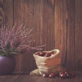 Heathers in ceramic pots and horse chestnuts in a jute bag