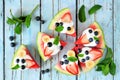 Heathy watermelon pizza witHealthy watermelon pizza with blueberries, strawberries, bananas and yogurt, top view over blue wood Royalty Free Stock Photo