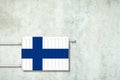 Heating battery, in the colors of the Finland flag on a concrete wall. Copy space. Raising heating prices. Heat saving