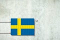 Heating battery, in the colors of the Sweden flag on a concrete wall. Copy space. Raising heating prices. Heat saving